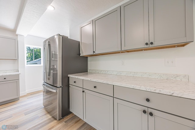 1814 5th St N, Fargo, ND 58102 - kitchen featuring gray cabinetry, stainless steel fridge, light wood-style flooring, and baseboards