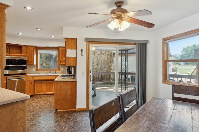 1412 10th Ave W, Shakopee, MN 55379 - kitchen with stainless steel appliances, healthy amount of natural light, brown cabinetry, ceiling fan, and recessed lighting