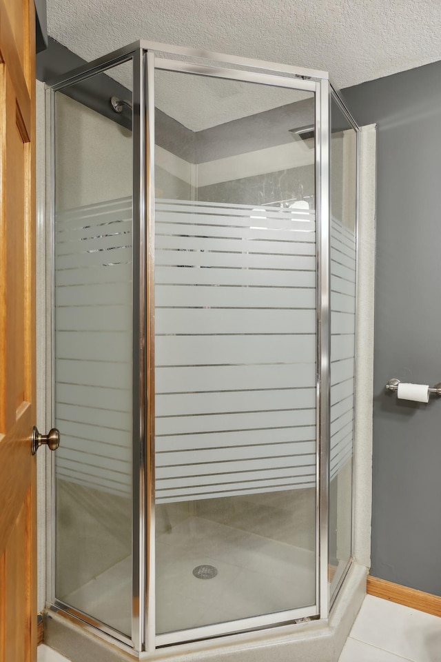 1412 10th Ave W, Shakopee, MN 55379 - full bathroom featuring a stall shower, a textured ceiling, and tile patterned floors