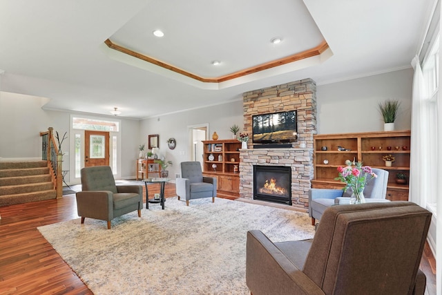 13478 Clearwater Cir, Rogers, MN 55374 - living room with stairway, a tray ceiling, a fireplace, wood finished floors, and ornamental molding