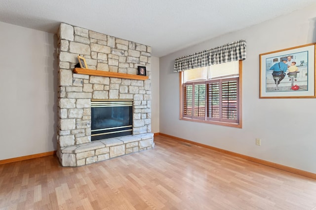 1580 9th Street Cir SE, Forest Lake, MN 55025 - unfurnished living room with wood finished floors, a fireplace, baseboards, and a textured ceiling