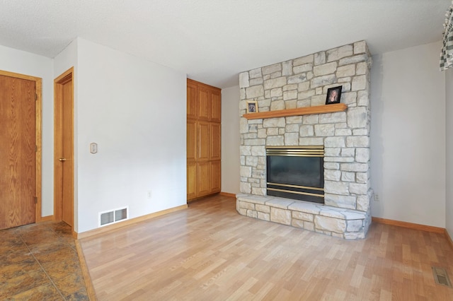 1580 9th Street Cir SE, Forest Lake, MN 55025 - unfurnished living room featuring a stone fireplace, baseboards, and wood finished floors