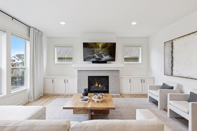 5175 White Star Ln, Woodbury, MN 55129 - living area featuring light wood-style flooring, healthy amount of natural light, a glass covered fireplace, and recessed lighting