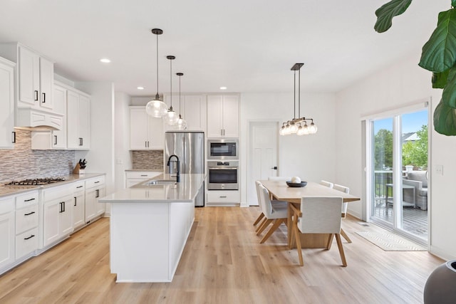 5175 White Star Ln, Woodbury, MN 55129 - kitchen featuring a sink, light wood-style flooring, decorative backsplash, stainless steel refrigerator with ice dispenser, and recessed lighting