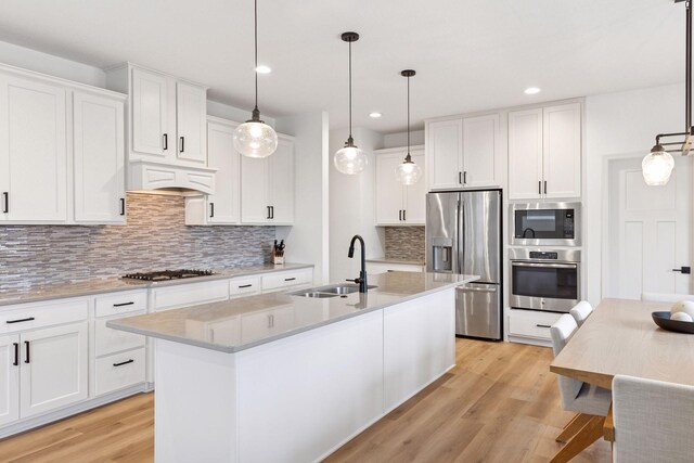 5175 White Star Ln, Woodbury, MN 55129 - kitchen with appliances with stainless steel finishes, a sink, light wood finished floors, backsplash, and white cabinetry