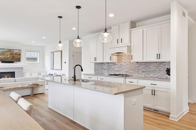 5175 White Star Ln, Woodbury, MN 55129 - kitchen with light wood-style flooring, backsplash, a sink, custom exhaust hood, and open floor plan