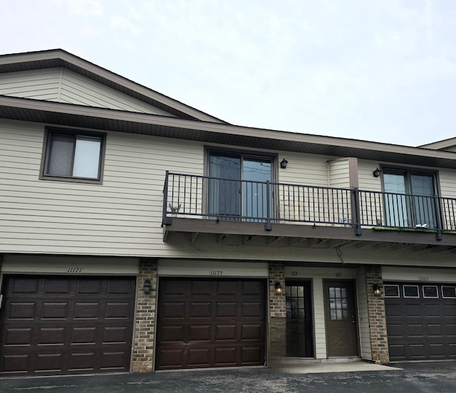 11173 Edgewood Cir N, Champlin, MN 55316 - view of front of property with a balcony, a garage, and brick siding