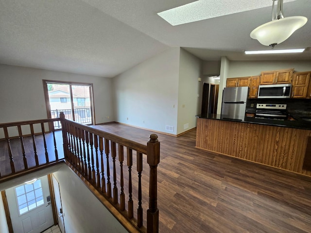 11173 Edgewood Cir N, Champlin, MN 55316 - kitchen with appliances with stainless steel finishes, dark wood-type flooring, brown cabinetry, dark countertops, and vaulted ceiling