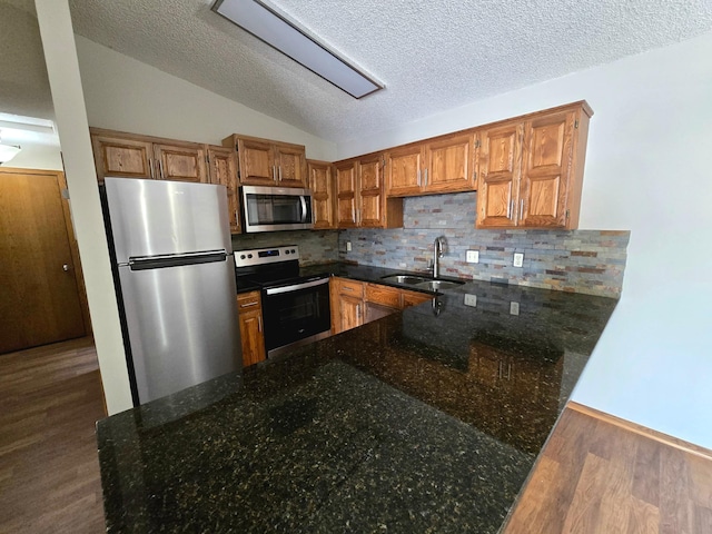 11173 Edgewood Cir N, Champlin, MN 55316 - kitchen with stainless steel appliances, a sink, wood finished floors, dark stone countertops, and decorative backsplash