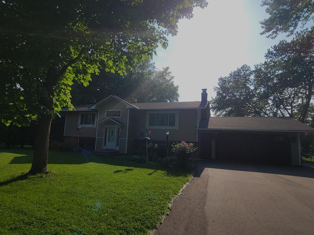 17296 Casey Ct, Prior Lake, MN 55372 - split level home with asphalt driveway, a garage, a front lawn, and a chimney