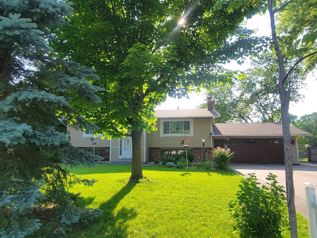 17296 Casey Ct, Prior Lake, MN 55372 - view of front of home with an attached garage, a front lawn, a chimney, concrete driveway, and brick siding