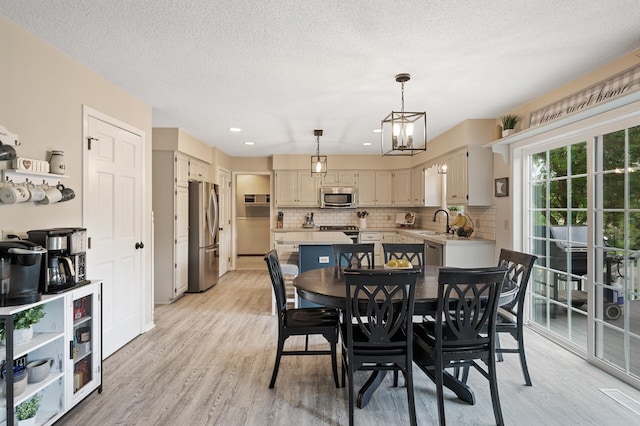 4142 Joppa Cir, Savage, MN 55378 - dining room with light wood-type flooring, a textured ceiling, a chandelier, and recessed lighting