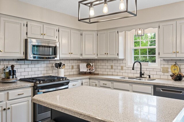 4142 Joppa Cir, Savage, MN 55378 - kitchen featuring stainless steel appliances, a sink, tasteful backsplash, and white cabinetry