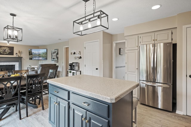 4142 Joppa Cir, Savage, MN 55378 - kitchen featuring freestanding refrigerator, light wood-type flooring, a center island, light countertops, and decorative light fixtures