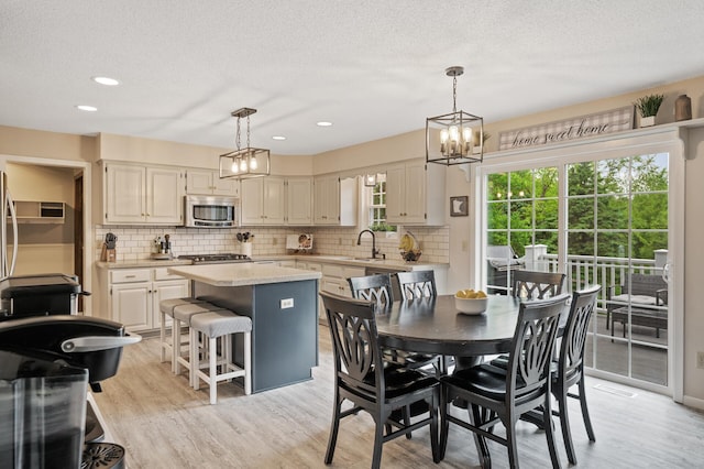 4142 Joppa Cir, Savage, MN 55378 - dining area with light wood-type flooring, a textured ceiling, a chandelier, and recessed lighting