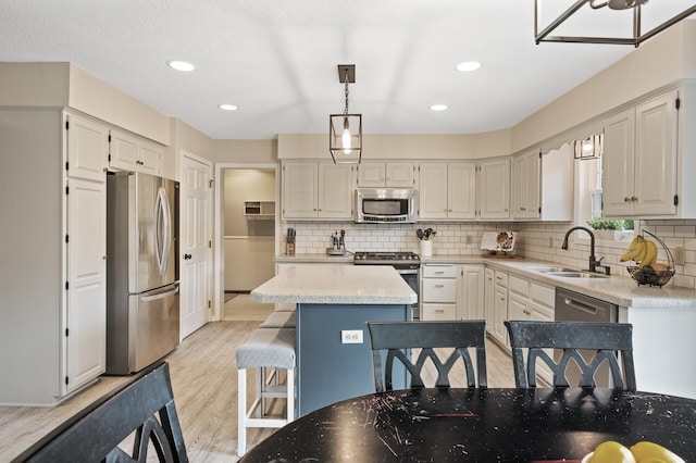 4142 Joppa Cir, Savage, MN 55378 - kitchen featuring appliances with stainless steel finishes, a sink, light wood finished floors, tasteful backsplash, and recessed lighting