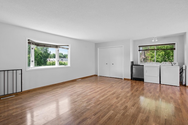 2125 White Bear Ave N, Maplewood, MN 55109 - unfurnished living room with washing machine and clothes dryer, wood finished floors, and baseboards