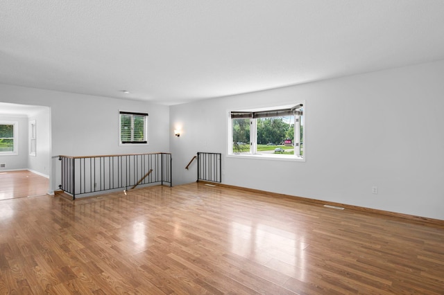 2125 White Bear Ave N, Maplewood, MN 55109 - spare room featuring healthy amount of natural light, wood finished floors, and baseboards