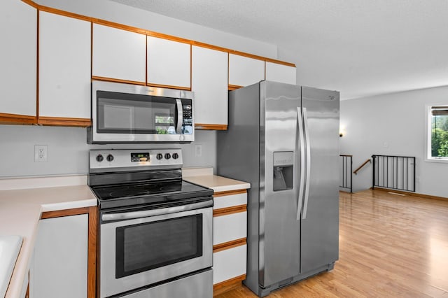 2125 White Bear Ave N, Maplewood, MN 55109 - kitchen with appliances with stainless steel finishes, light countertops, and white cabinets