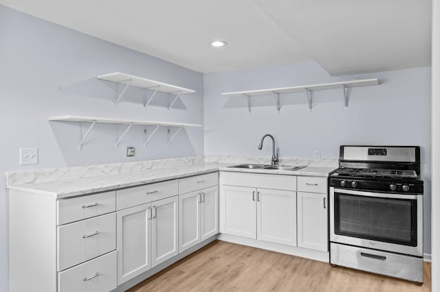 2125 White Bear Ave N, Maplewood, MN 55109 - kitchen featuring open shelves, stainless steel gas range oven, a sink, white cabinets, and light wood finished floors