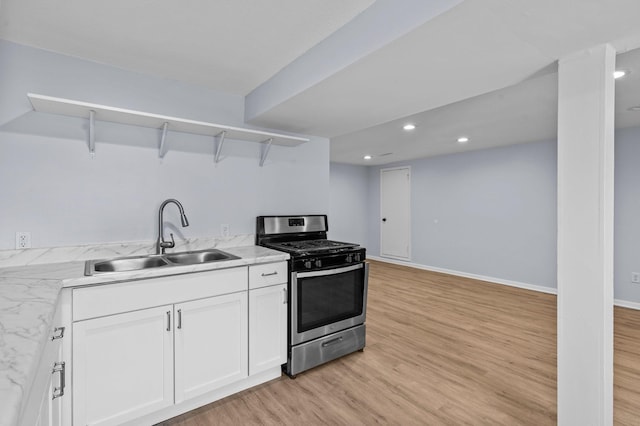 2125 White Bear Ave N, Maplewood, MN 55109 - kitchen with gas stove, open shelves, a sink, light wood-style flooring, and white cabinetry
