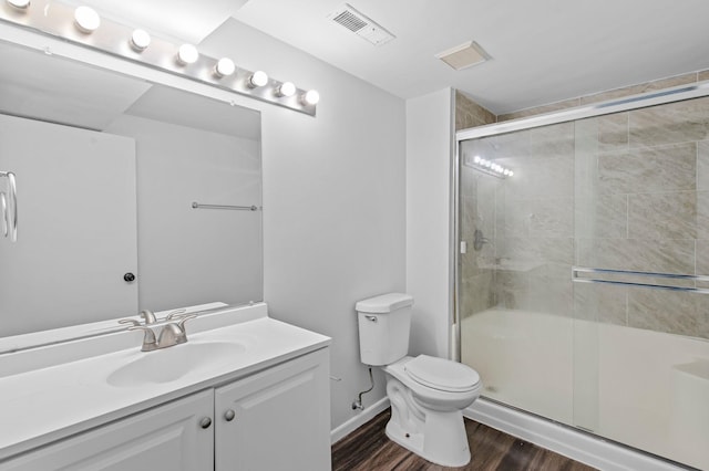2125 White Bear Ave N, Maplewood, MN 55109 - bathroom featuring toilet, wood finished floors, a shower with door, and vanity
