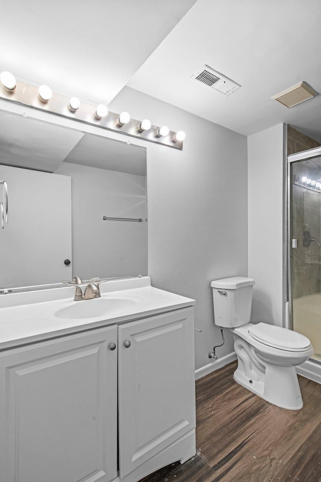 2125 White Bear Ave N, Maplewood, MN 55109 - full bathroom with toilet, wood finished floors, vanity, a stall shower, and baseboards