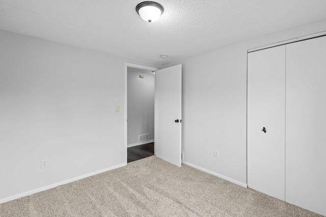 2125 White Bear Ave N, Maplewood, MN 55109 - unfurnished bedroom with carpet, a closet, a textured ceiling, and baseboards