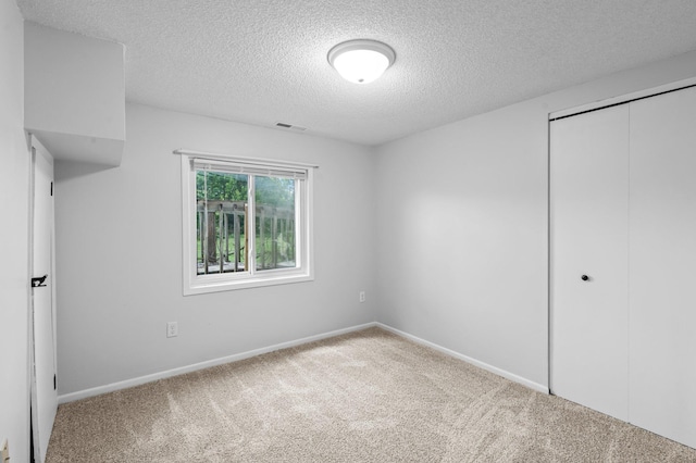 2125 White Bear Ave N, Maplewood, MN 55109 - unfurnished bedroom with a textured ceiling, carpet floors, a closet, and baseboards