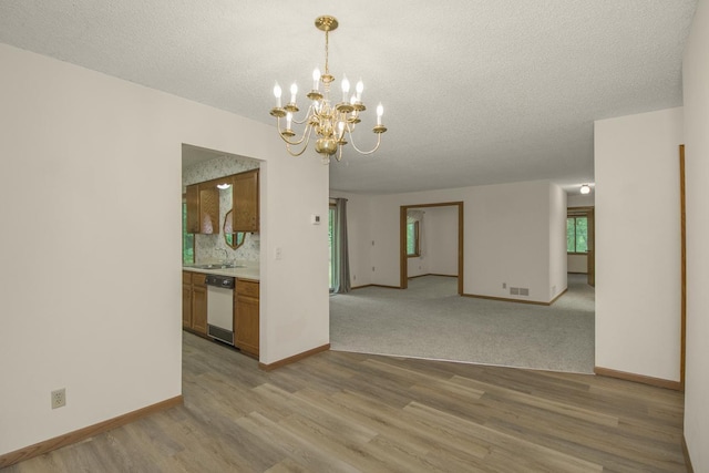 2 Crusader Ave E Unit A, West Saint Paul, MN 55118 - empty room featuring light wood finished floors, a chandelier, and a textured ceiling