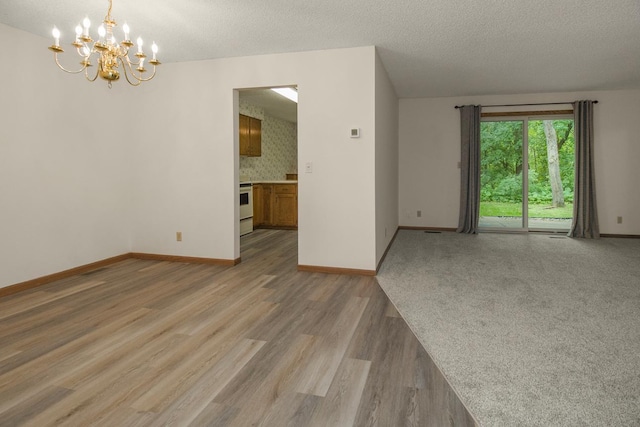 2 Crusader Ave E Unit A, West Saint Paul, MN 55118 - spare room with a chandelier, light wood-style flooring, and a textured ceiling