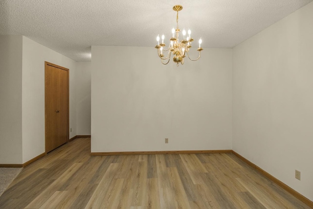 2 Crusader Ave E Unit A, West Saint Paul, MN 55118 - spare room featuring light wood-style flooring, a textured ceiling, and a chandelier