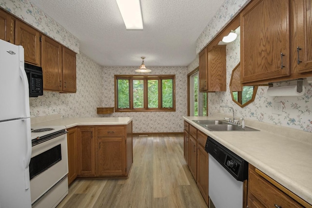 2 Crusader Ave E Unit A, West Saint Paul, MN 55118 - kitchen featuring white appliances, wallpapered walls, light wood-style floors, brown cabinets, and a textured ceiling