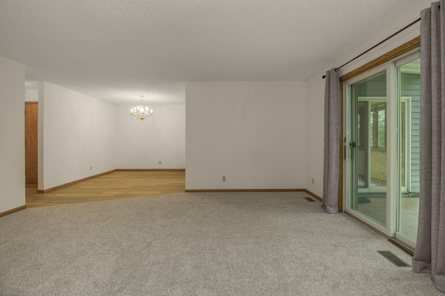 2 Crusader Ave E Unit A, West Saint Paul, MN 55118 - spare room with light carpet, a chandelier, and a textured ceiling