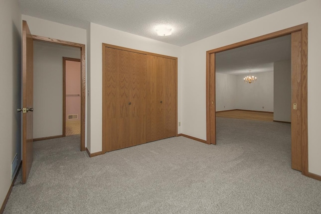 2 Crusader Ave E Unit A, West Saint Paul, MN 55118 - unfurnished bedroom featuring carpet flooring, a closet, a chandelier, and a textured ceiling