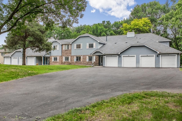 2 Crusader Ave E Unit A, West Saint Paul, MN 55118 - view of property with a front lawn, asphalt driveway, a chimney, an attached garage, and roof with shingles