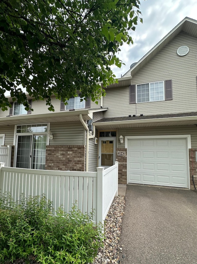 2542 Mallard Dr, Woodbury, MN 55125 - view of front of house featuring brick siding, a garage, and asphalt driveway