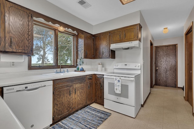 37875 600th Ave, Eden Valley, MN 55329 - kitchen with white appliances, under cabinet range hood, light countertops, dark brown cabinets, and light floors