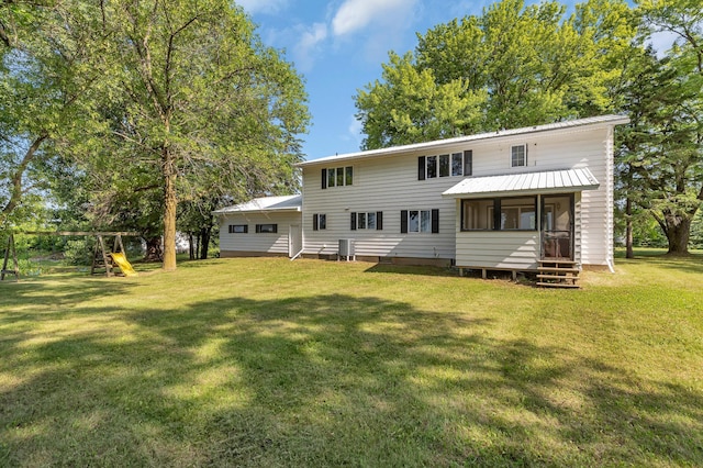 37875 600th Ave, Eden Valley, MN 55329 - rear view of house featuring a sunroom, a yard, entry steps, a metal roof, and a playground