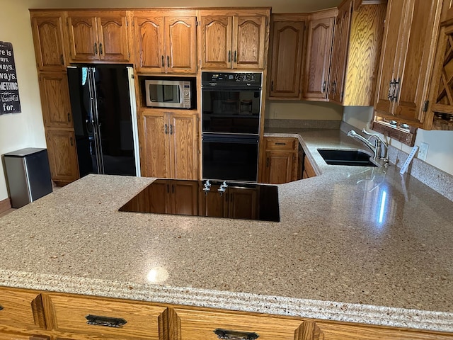 70 Lakeview Dr, Slayton, MN 56172 - kitchen with black appliances, a sink, brown cabinetry, and light stone countertops