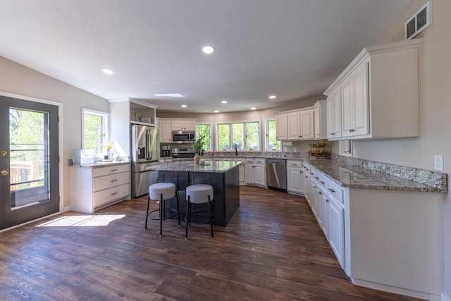 25397 Island View Dr, Cohasset, MN 55721 - kitchen with appliances with stainless steel finishes, white cabinetry, dark wood-type flooring, recessed lighting, and a center island