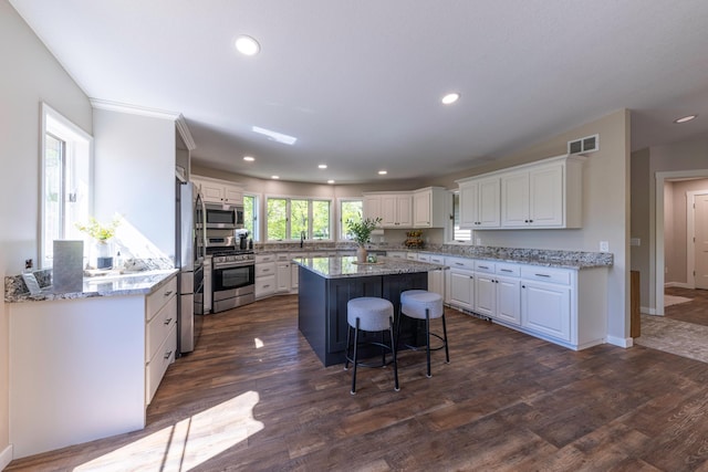 25397 Island View Dr, Cohasset, MN 55721 - kitchen with appliances with stainless steel finishes, a center island, white cabinetry, a sink, and recessed lighting