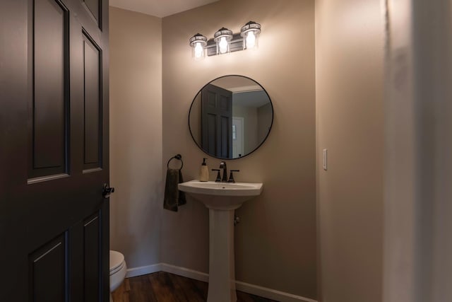 25397 Island View Dr, Cohasset, MN 55721 - bathroom with baseboards, wood finished floors, toilet, and a sink