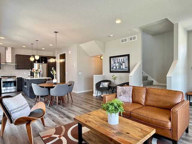 4848 161st St W, Lakeville, MN 55044 - living room featuring light wood-style floors, recessed lighting, stairway, a textured ceiling, and baseboards