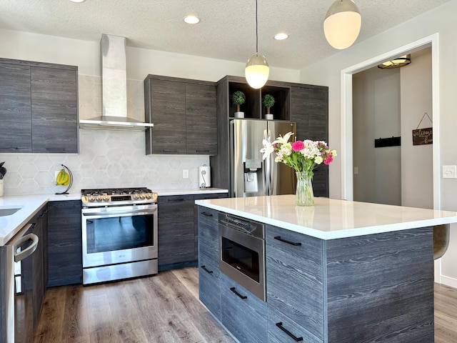 4848 161st St W, Lakeville, MN 55044 - kitchen featuring wall chimney range hood, stainless steel appliances, modern cabinets, wood finished floors, and light countertops