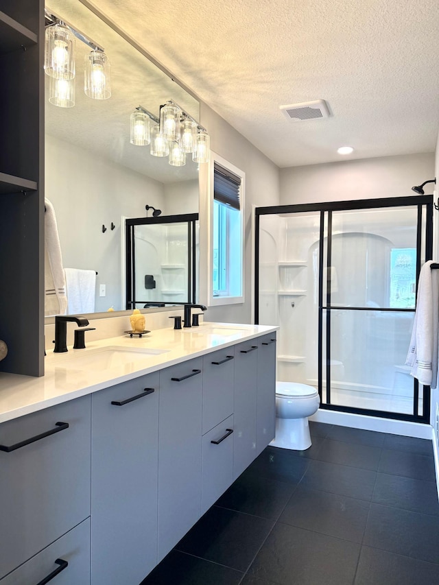 4848 161st St W, Lakeville, MN 55044 - bathroom with a shower stall, double vanity, toilet, tile patterned floors, and a textured ceiling