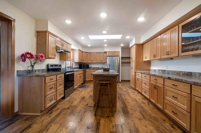 505 Superior Ave, Crosby, MN 56441 - kitchen with appliances with stainless steel finishes, a skylight, dark countertops, a kitchen island, and dark wood finished floors