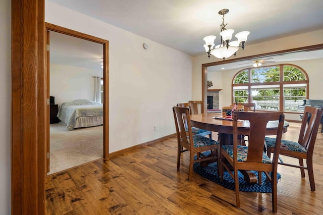 505 Superior Ave, Crosby, MN 56441 - dining space featuring a chandelier, wood finished floors, ceiling fan, and a fireplace