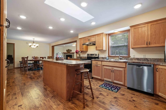 505 Superior Ave, Crosby, MN 56441 - kitchen featuring stainless steel appliances, dark wood finished floors, dark countertops, a kitchen island, and recessed lighting