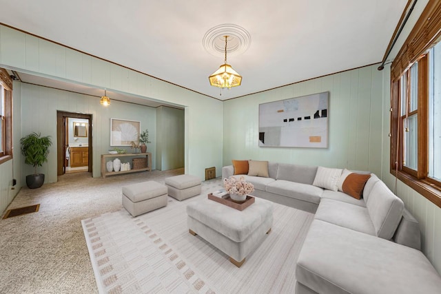 912 State St N, Waseca, MN 56093 - carpeted living room with a chandelier and wood walls